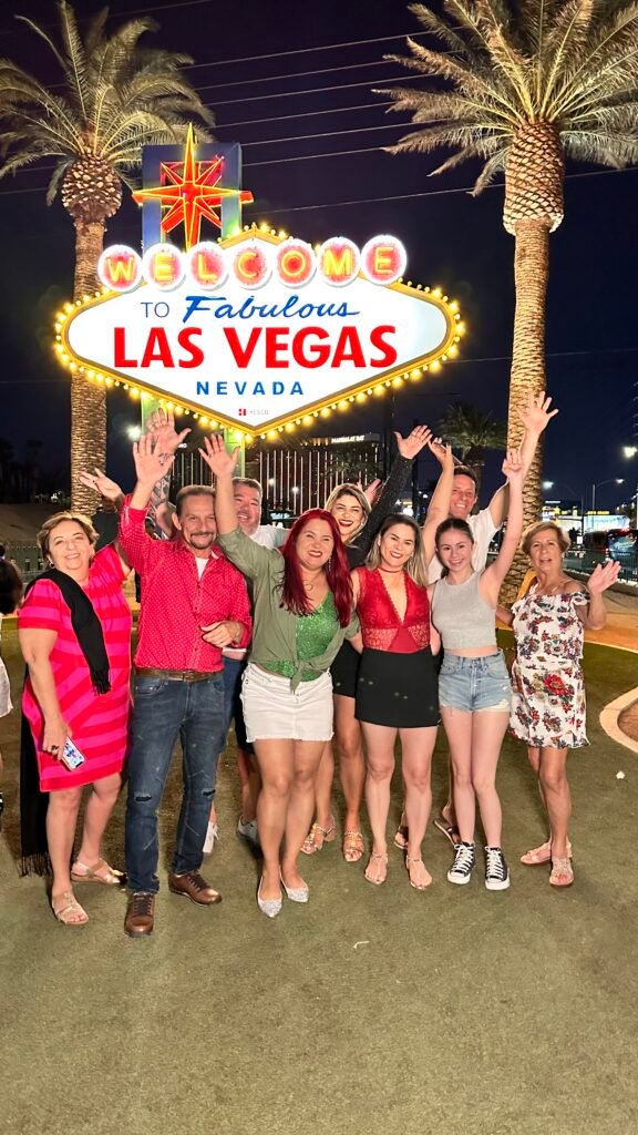 Grupo de pessoas em frente à placa da cidade de Las Vegas