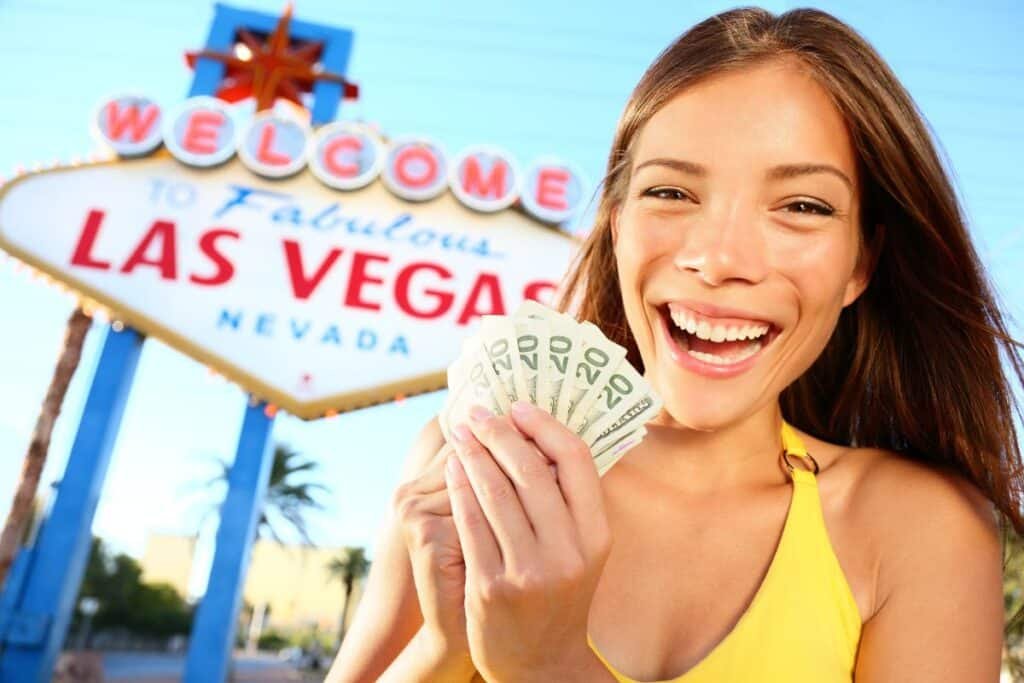 Garota sorrindo em frente a uma placa de Las Vegas